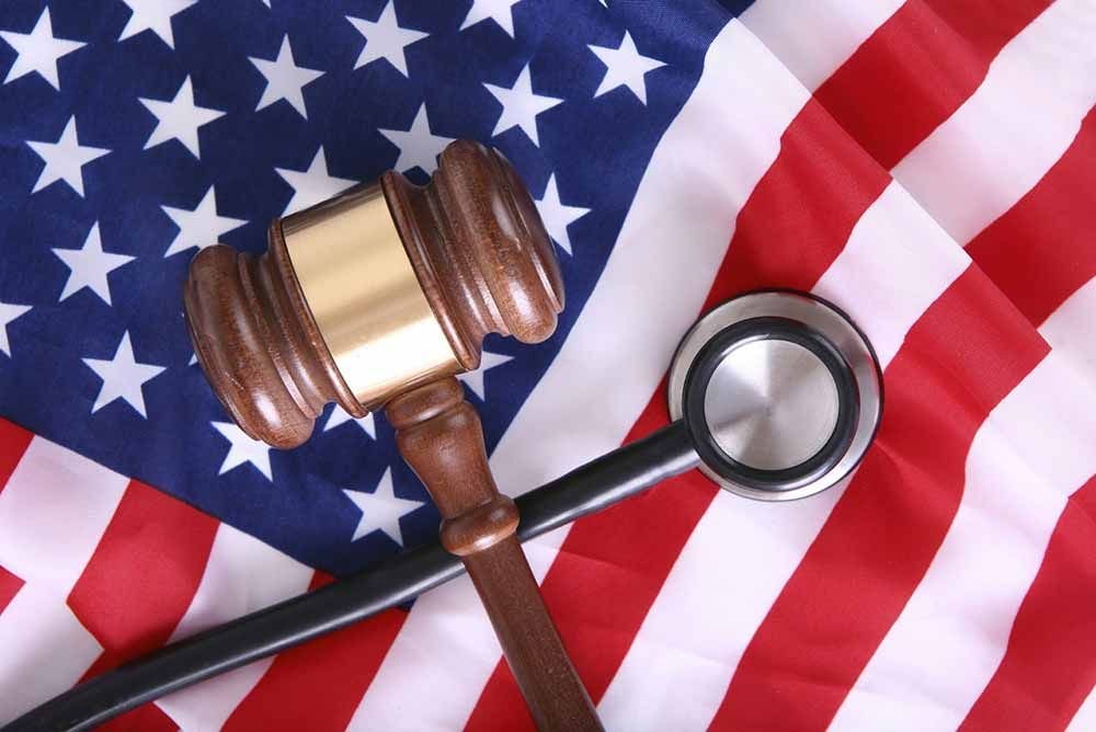 Judge's gavel and stethoscope resting on a United States flag